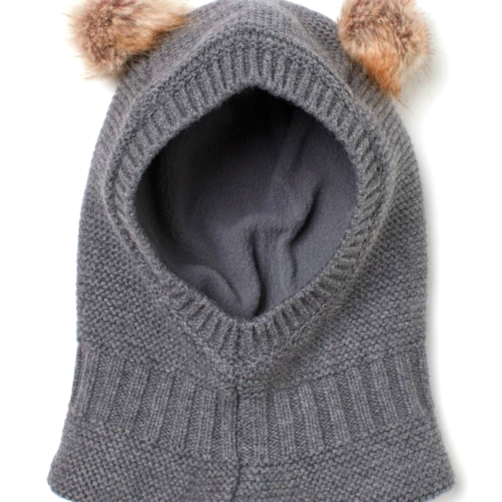 Knit balaclava in soft cotton with faux fur pompoms at top. Fleece lining,
